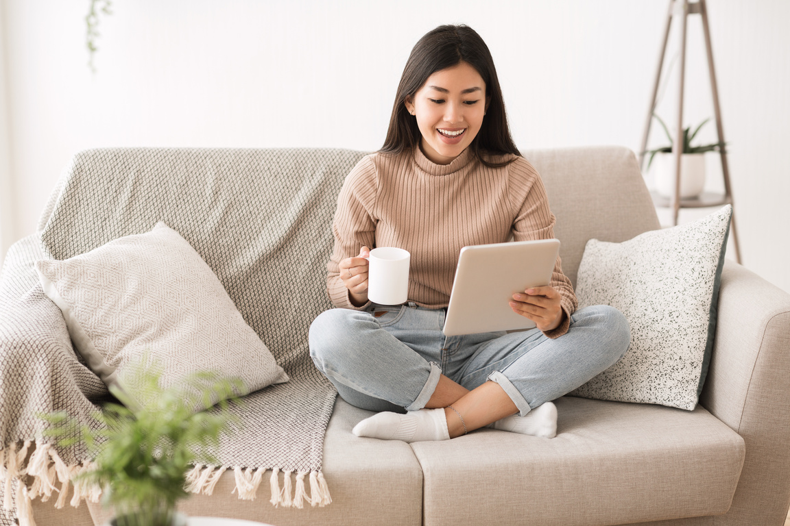 Interesting content. Happy girl reading blog on digital tablet